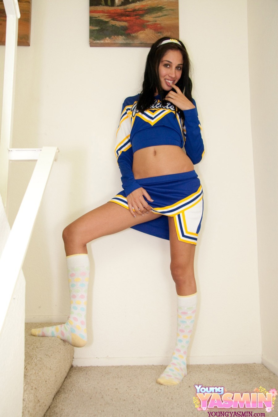 Teen brunette teasing in sexy cheerleader uniform
