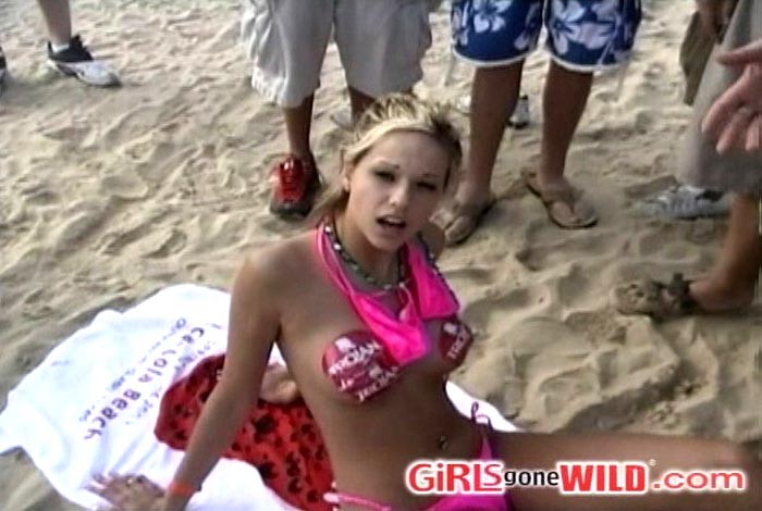 Busty blonde beach babe covers her nips with stickers