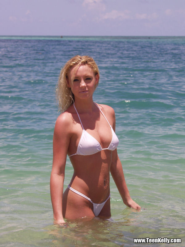 Cute innocent blonde teen on the beach in a bikini