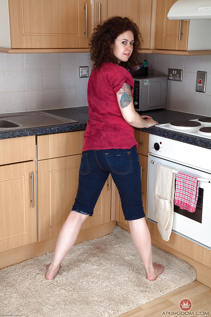 Mature brunette woman Candy revealing hairy snatch while disrobing in kitchen