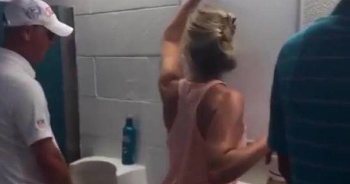 Woman pees in a men's urinal at football game