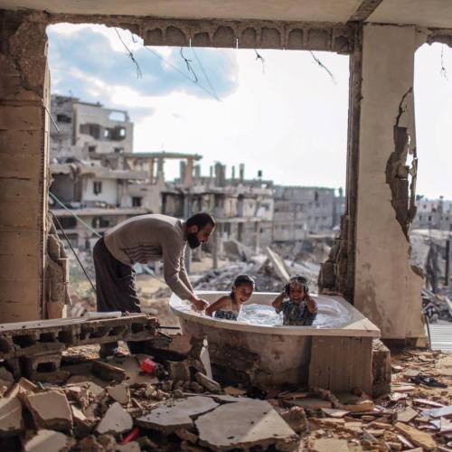 sixpenceee: Palestinian father bathing his daughter and niece in their destroyed home. I thought this was so precious. 