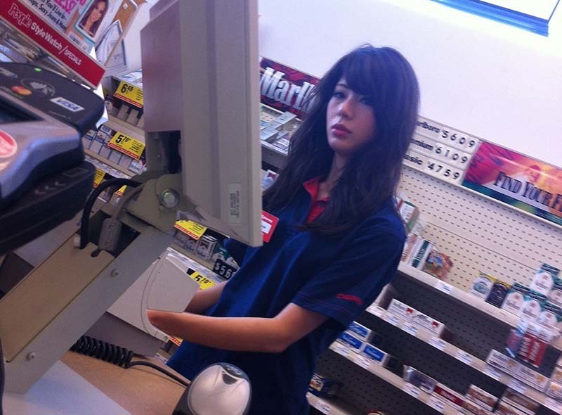 Cute brunette teen at a convenience store working the cash register